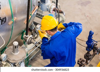 Technician In Factory At Machine Maintenance Working With Wrench, Top View On The Man