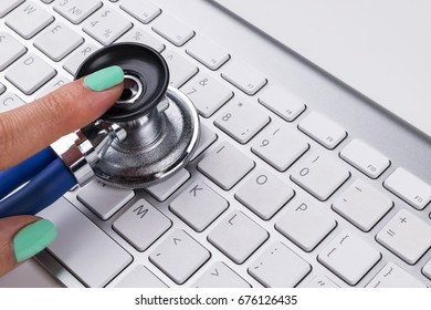 Technician Female (woman) Hand Using Stethoscope For Examines Computer Keyboard, Computer Service Concept, Computer And Internet Maintenance, Checking The Health Of Laptop Computer