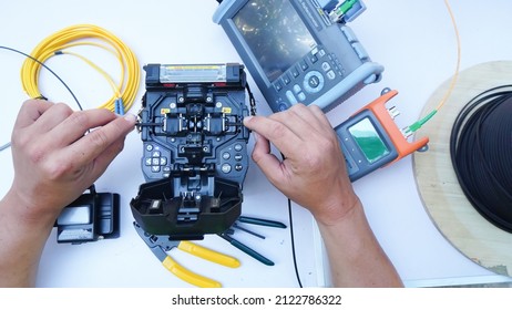 Technician Fiberoptic Fusion Splicing. Worker connecting for Cable Internet signal and Wire connection with Fiber Optic Fusion Splicing machine,fiber optic cable splice machine in work