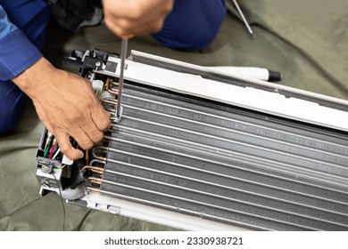 Technician is fixing or checking the evaporator system, troubleshooting air conditioning unit or dismantling for air conditioner fan coil unit cleaning,repair and maintenance,install air conditioner