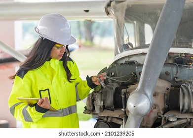 Technician fixing the engine of the airplane,Female aerospace engineering checking aircraft engines,Asian mechanic maintenance inspects plane engine - Shutterstock ID 2101239205