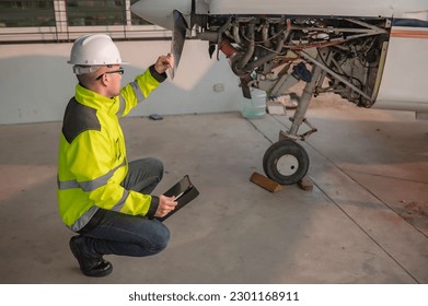 Technician fixing the engine of the airplane,Female aerospace engineering checking aircraft engines,Asian mechanic maintenance inspects plane engine - Powered by Shutterstock