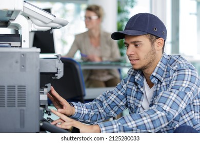 a technician fixing a printer - Shutterstock ID 2125280033