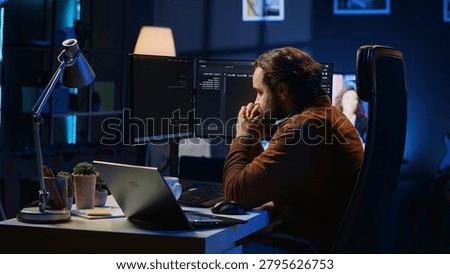 Technician focused on typing complex code in neon lit home office, developing software application. IT specialist removing headphones to better concentrate on difficult task, camera A.
