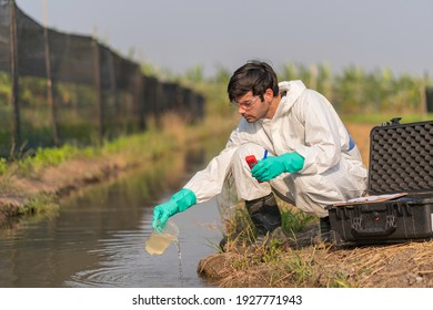 A technician in full body protective suit collecting sample of water ,Portable water quality measurement ,water quality for agriculture ,ph checking on field - Shutterstock ID 1927771943
