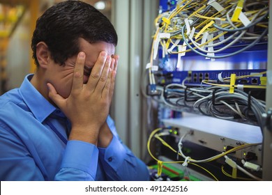 Technician getting stressed over server maintenance in server room - Powered by Shutterstock