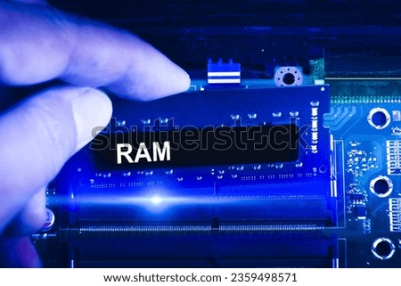 Technician hand insert RAM memory to memory slot on computer motherboard. Technician upgrade RAM memory into laptop. blue tone, Computer technology concept.