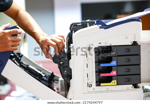 Technician hand open cover photocopier or\
photocopy to fix paper jam and replace ink cartridges for scanning\
fax or copy document in office\
workplace.