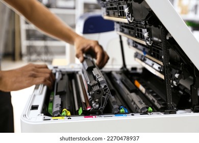 Technician hand open cover printer photocopier or photocopy to replace ink cartridges or fix paper jam for scanning fax or copy document in office workplace. - Shutterstock ID 2270478937