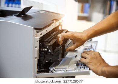 Technician hand open cover printer photocopier or photocopy to replace ink cartridges or fix paper jam for scanning fax or copy document in office workplace.