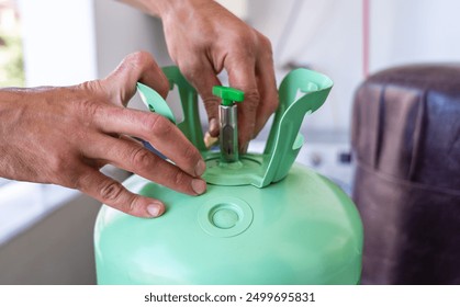 Technician hands adjusting valve on refrigerant tank during air conditioner maintenance. Professional HVAC service and repair, ensuring proper cooling system functionality - Powered by Shutterstock