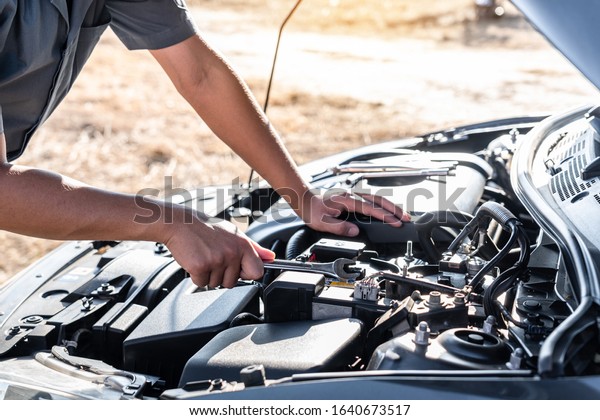 Technician hands of car mechanic in doing auto\
repair service and maintenance worker repairing vehicle with\
wrench, Service and Maintenance car\
check.