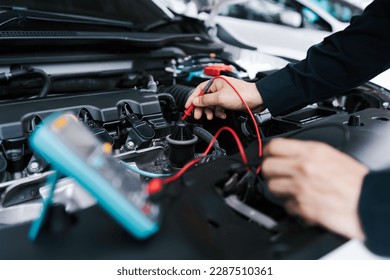 Technician Hands of car mechanic working repair in auto repair Service electric battery and Maintenance of car battery. Check the electrical system inside the car. - Powered by Shutterstock
