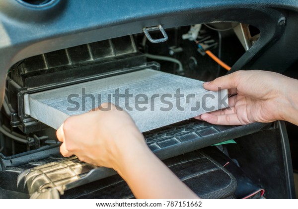 Technician hands holding air filter in car
repair service.