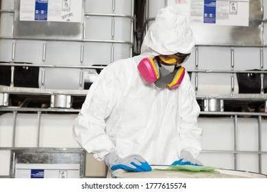 Technician In Hazmat Suit Reading Instructions On Paper