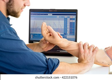 Technician Helps Man With Prosthetic Arm Using Computer Against A White Background