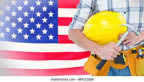 Technician holding hammer and hard hat against rippled us flag - Shutterstock ID 489111808