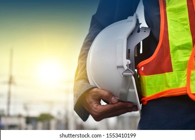 Technician holding white hat safety hard hat sunlight background