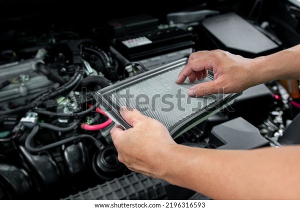 Technician holds Air flow filter of car\
engine to check the condition of use preliminary check before using\
the car to travel, Service concept photo of\
car