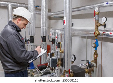 Technician inspecting heating system in boiler room