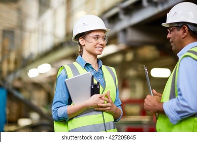 Technician inspecting a young trainee at factory - Shutterstock ID 427205845