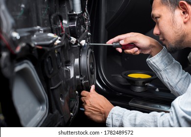Technician Installing The Car Speaker To The Car Door. Car Audio Installation Concept.