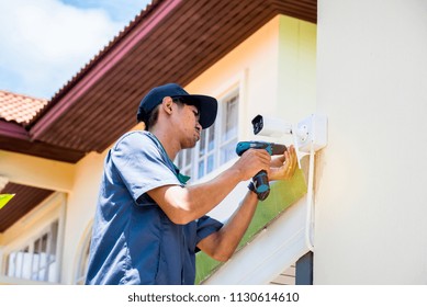 Technician Installing CCTV Camera System At Home For Security System