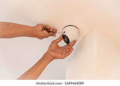 Technician Installing CCTV IP Camera In Corner For Home Security System.