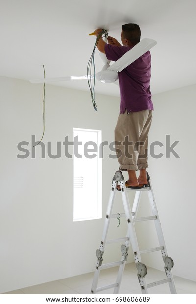 Technician Installing Ceiling Fan Newly Built Stock Photo