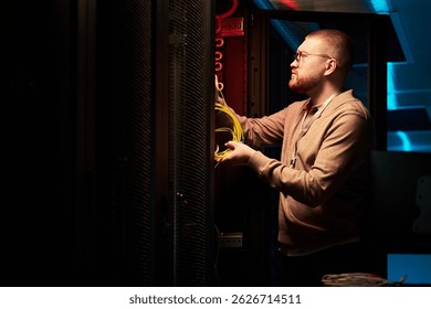 Technician Installing Network Cables in Server Room