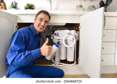 Technician Installing Reverse Osmosis Equipment Under The Sink With Ok Sign. Front View. Horizontal Composition.