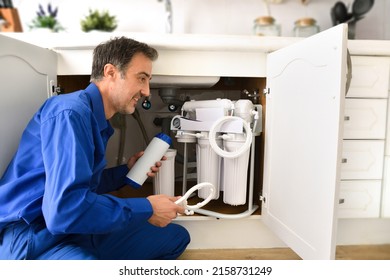 Technician Installing Reverse Osmosis Equipment Under The Sink. Front View. Horizontal Composition.