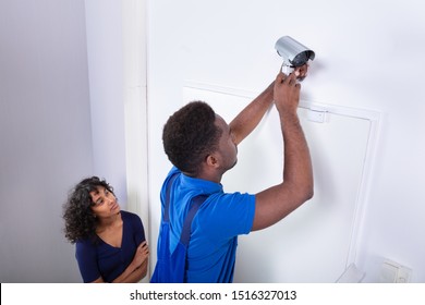 Technician Installing Security Camera System At Home