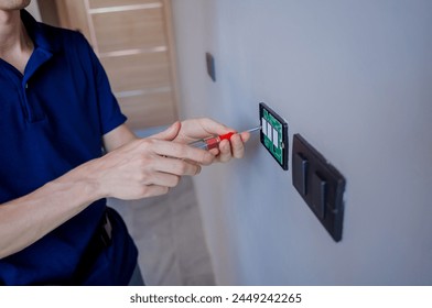 Technician installing sensor light switch at modern villa