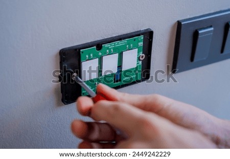 Technician installing sensor light switch at modern villa