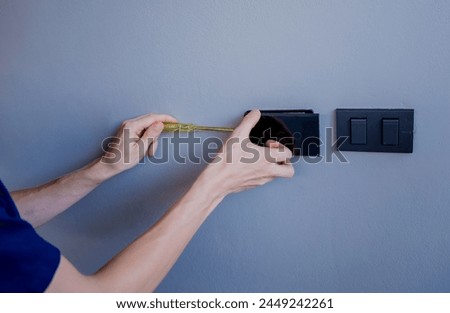 Technician installing sensor light switch at modern villa