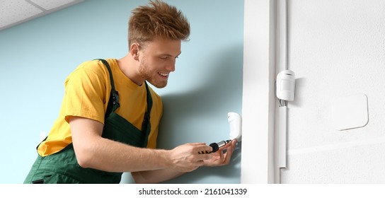 Technician Installing Smart Home Security System In Room