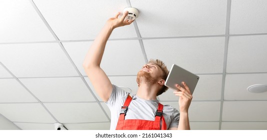 Technician Installing Smart Home Security System In Room