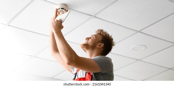 Technician Installing Smart Home Security System In Room