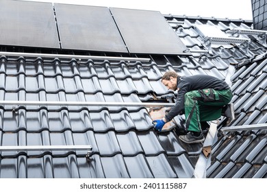 Technician Installing a Solar Panel Array on the Roof of a House