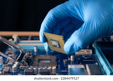 the technician installs the CPU in the computer motherboard - Powered by Shutterstock