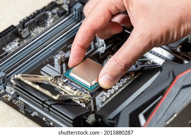 A technician installs an Intel i7-9700K CPU in 1151 socket on a Gigabyte motherboard. PC assembly and upgrade concept
