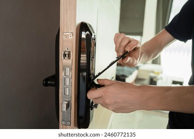 A technician installs a modern smart door lock on the wood door - Powered by Shutterstock