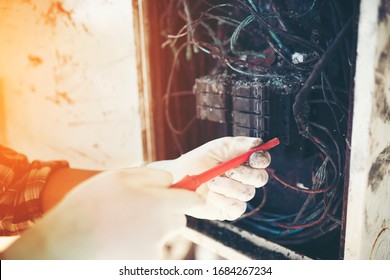 Technician Investigating Cause Of The Fire, Short Circuit  Electric Control Cabinet.