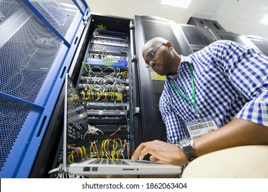 Technician with a laptop checking server in the data center