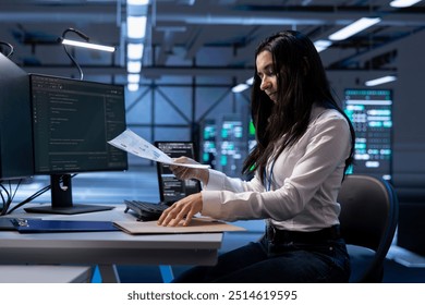 Technician maintaining accurate documentation of data center equipment, configurations, and procedures. Woman in server hub establishing performance benchmarks and conducting analysis