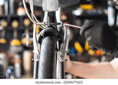 Technician makes adjustments to brake on a folding bicycle working in workshop , Bicycle Repair and maintenance concept - Powered by Shutterstock