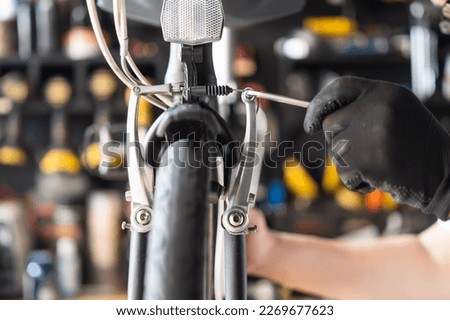 Technician makes adjustments to brake on a folding bicycle working in workshop , Bicycle Repair and maintenance concept
