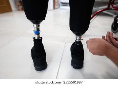 Technician making adjustments to prosthetic legs, highlighting precision and care in a rehabilitation setting. The image conveys innovation and the importance of personalized medical support. - Powered by Shutterstock