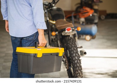 Technician man carrying toolbox, Mechanic repairing motorcycle in repair shop, Man repair motorbike in garage, Mechanic fixing motorcycle - Powered by Shutterstock